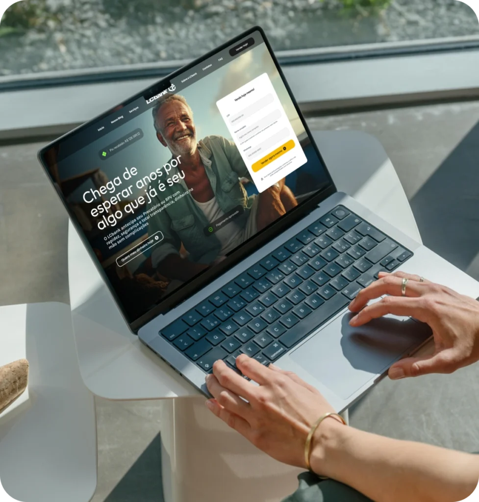 Laptop aberto com site LCbank exibindo login e homem sorrindo.